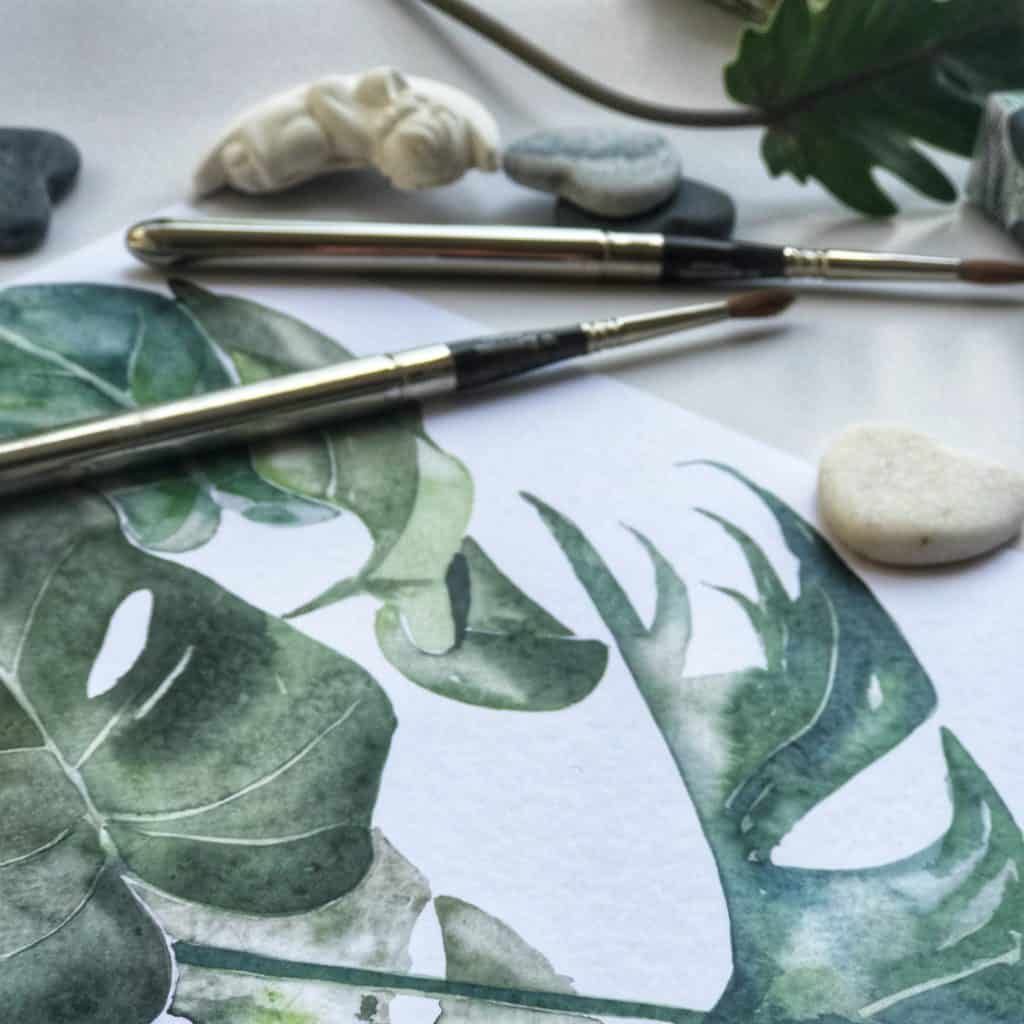 printed artwork of leaves and silver paintbrush